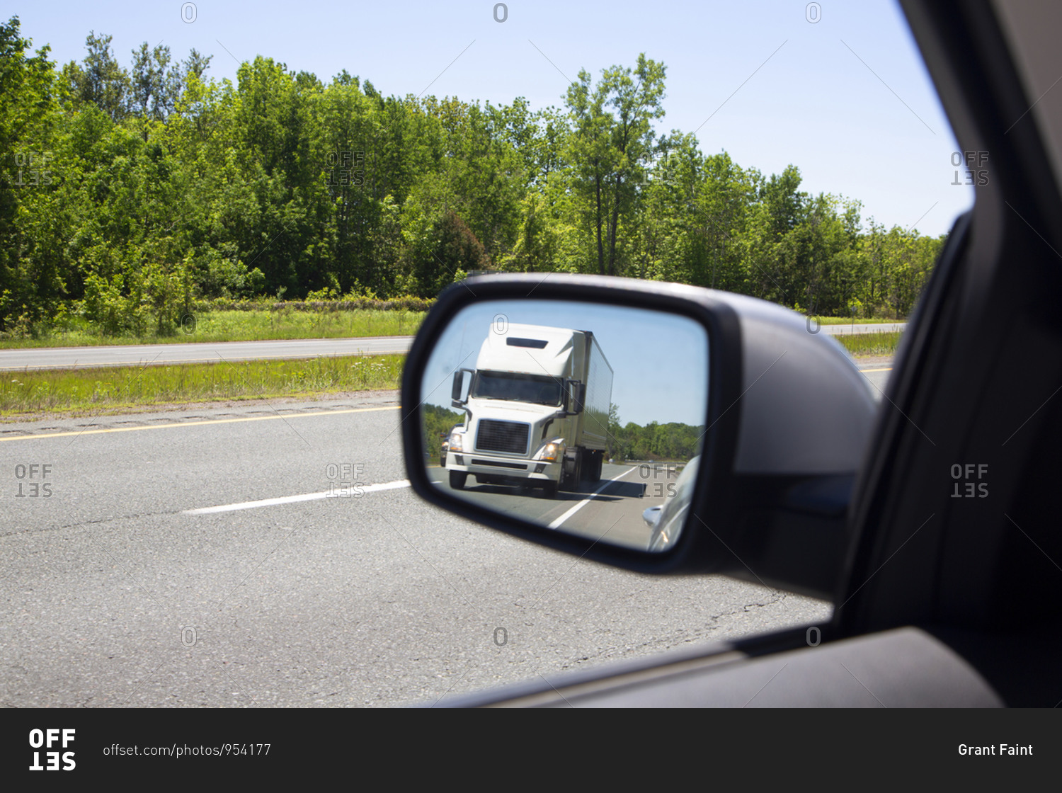 Semi trailer truck in rear view mirror driving on highway in northern New York State