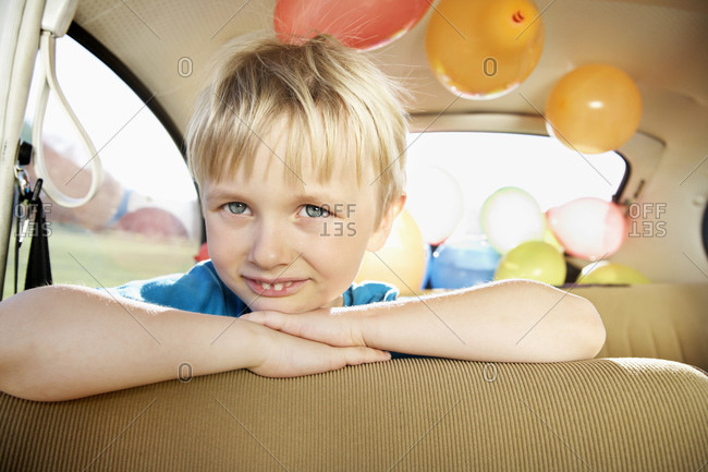 Germany- North Rhine Westphalia- Cologne- Portrait of boy leaning on car seat- smiling