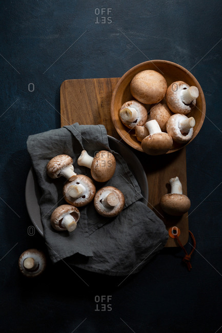 Overhead view of mushrooms on platter on wooden board