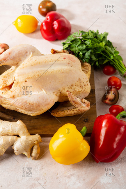 Whole uncooked chicken and vegetables