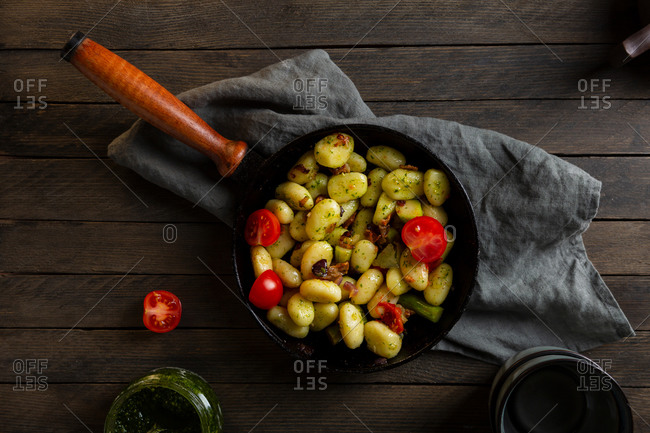 Overhead view of pan full of homemade potato gnocchi on wooden table