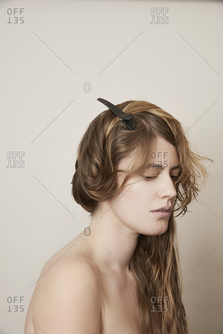 Young woman with long blonde hair pinned up in a clip during a haircut