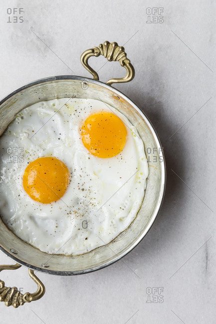 Overhead view of fried eggs in an antique skillet
