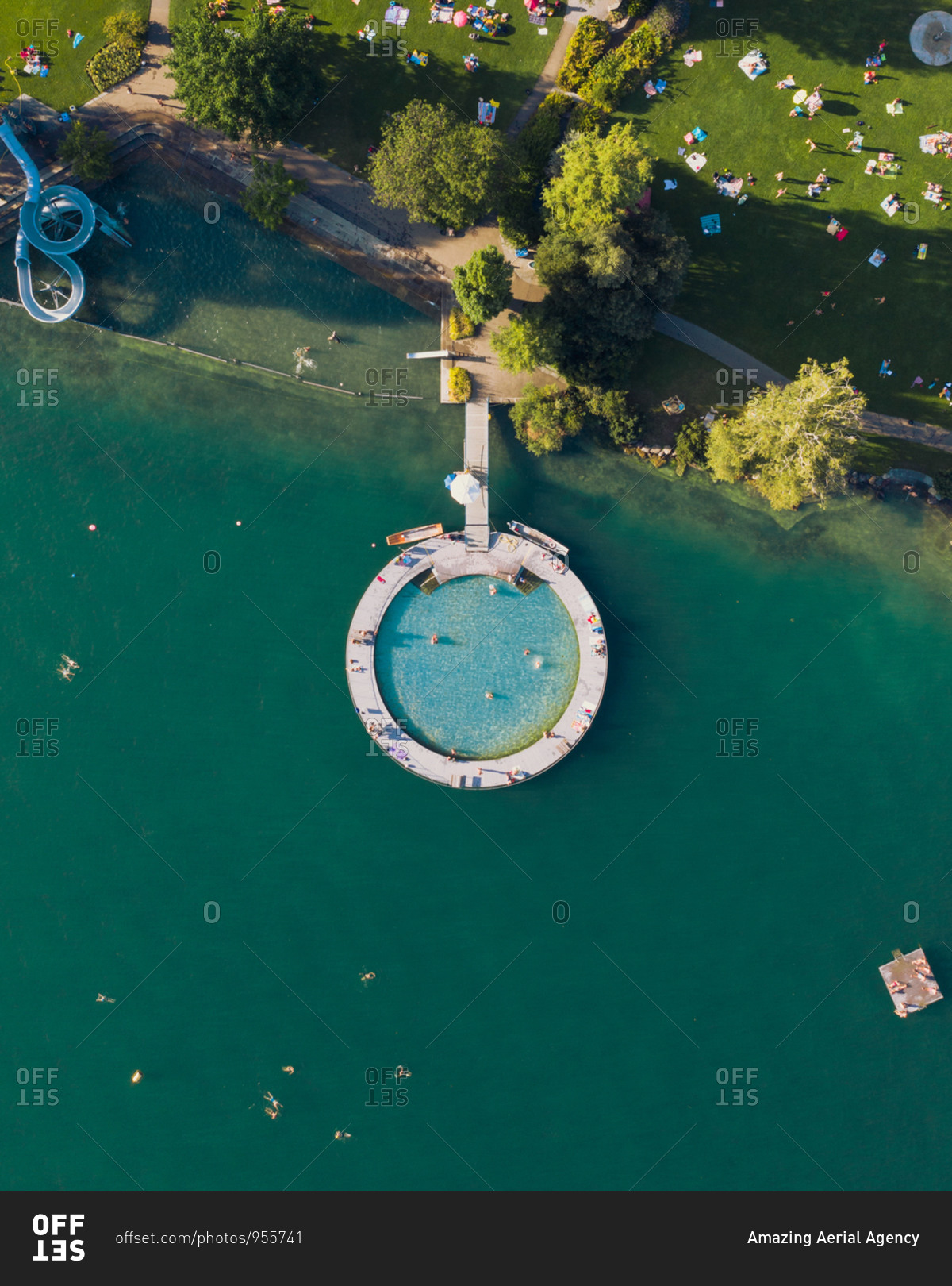Aerial view of an outdoor public pool that looks like the search logo. a slide in the shape of the g of google and some swimmer in Zurich Switzerland