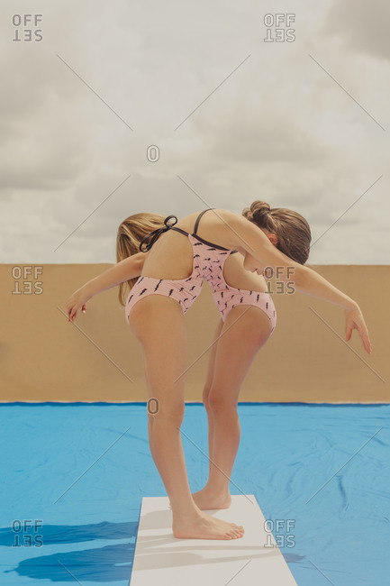 Two girls playing swimming pool on roof terrace