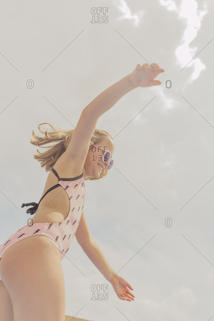 Happy girl wearing pink sunglasses and swimsuit having fun