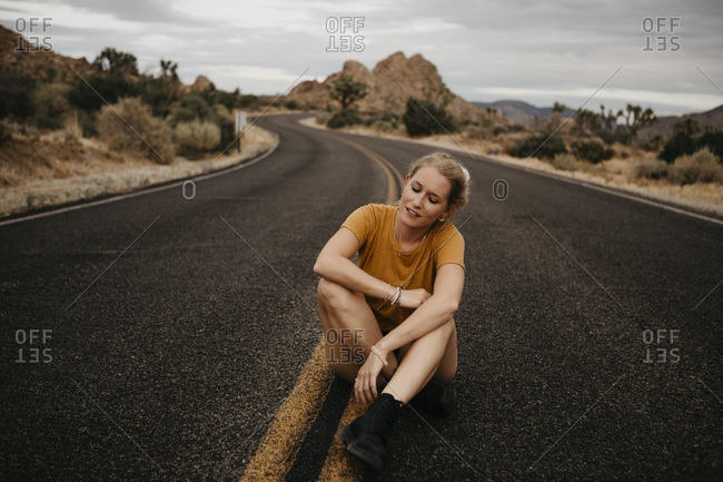 Woman sitting on road- Joshua Tree National Park- California- USA