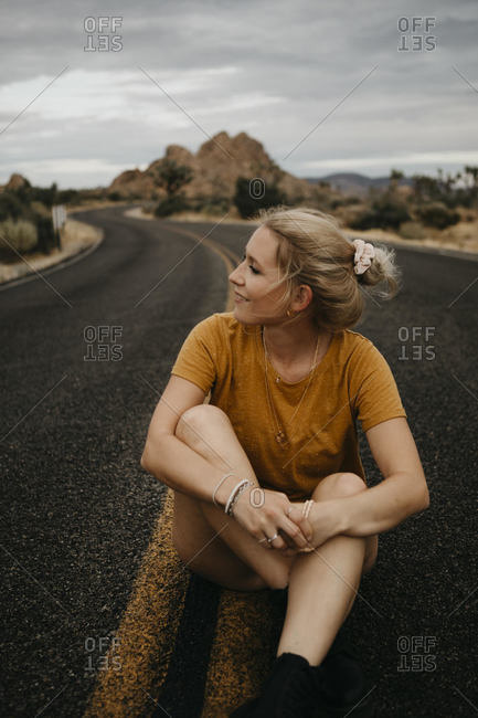 Woman sitting on road- Joshua Tree National Park- California- USA