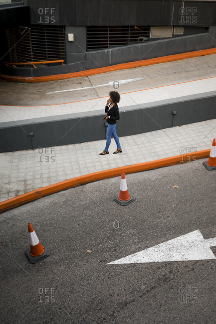 Businesswoman on the phone walking on pavement
