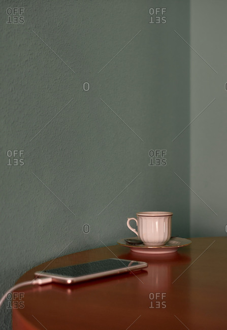 Coffee cup and teapot on a corner table. Conceptual image
