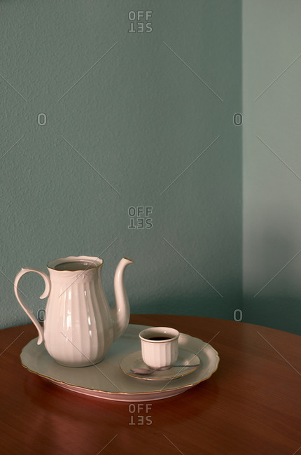 Coffee cup and teapot on a corner table. Conceptual image