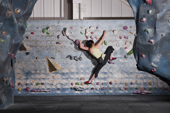 Mature woman practicing at indoor climbing wall in the UK