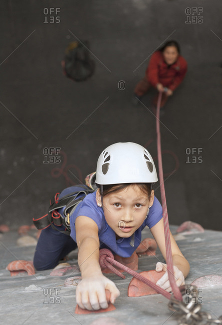 Young girl climbing at indoor climbing wall in England / UK