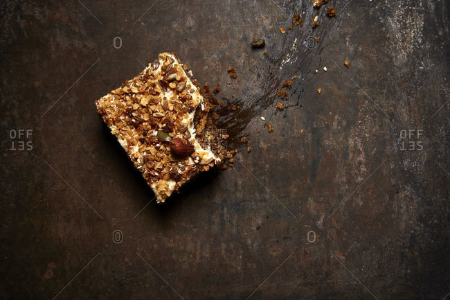 Piece of carrot cake missing a bite on dark background
