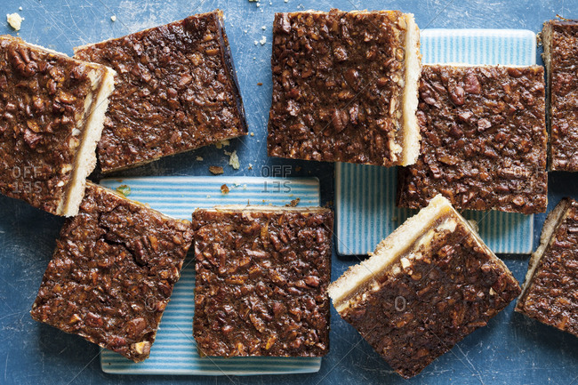Squares of pecan nut bars arranged on a blue background