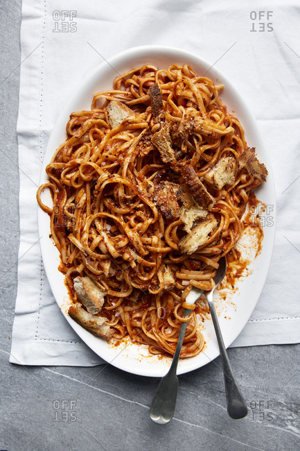 Fresh pasta in a tomato sauce with croutons on a white linen cloth,