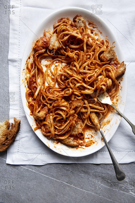 Fresh pasta in a tomato sauce with croutons on a white linen cloth,