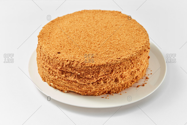 Homemade delicious freshly cooked sweet dessert - beautiful tasty honey biscuit on a ceramic plate on a white background, copy space.