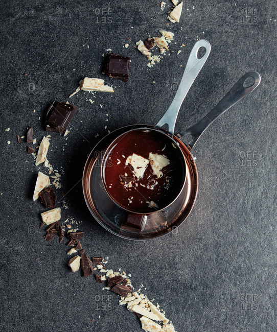White and dark chocolate in a pan on gray background