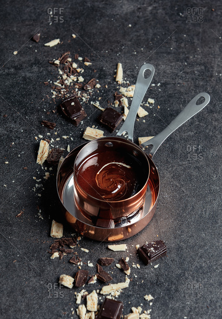White and dark chocolate in a pan on gray background