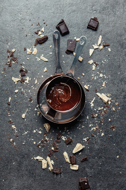 White and dark chocolate in a pan on gray background