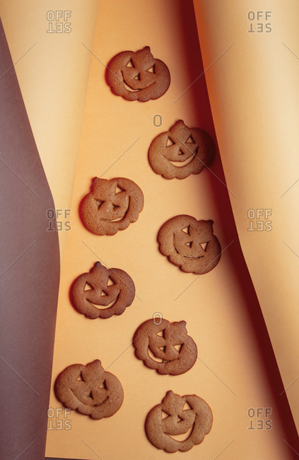 Pumpking halloween cookies in brown and yellow background