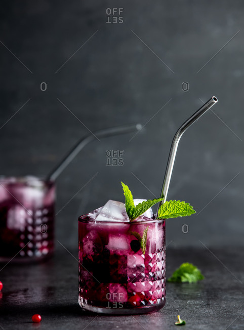 Drink with mint, blackberries, raspberries and cranberries in glasses on a table