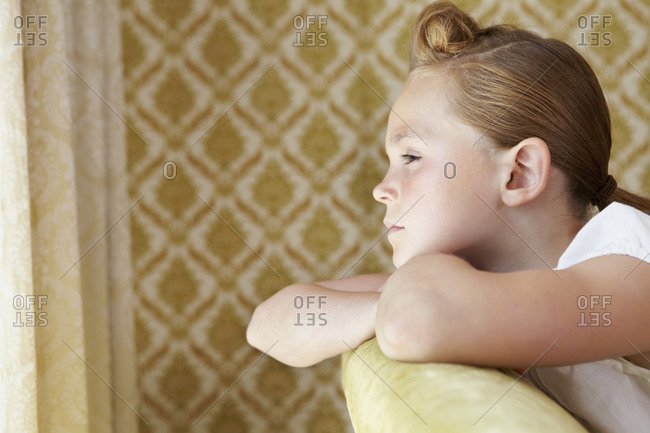 Serious girl leaning on a couch