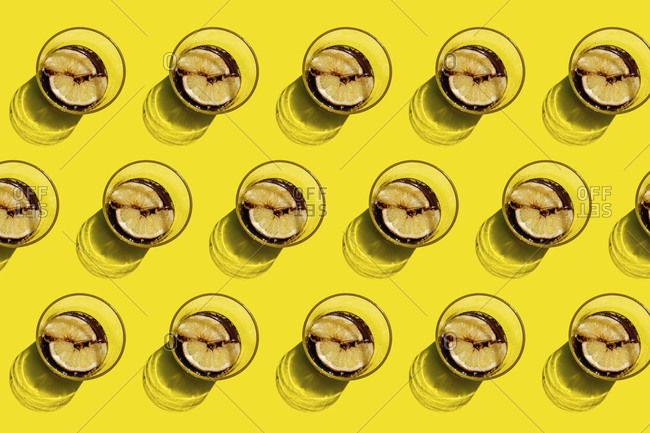 Pattern of rows of cola glasses with lemon slices