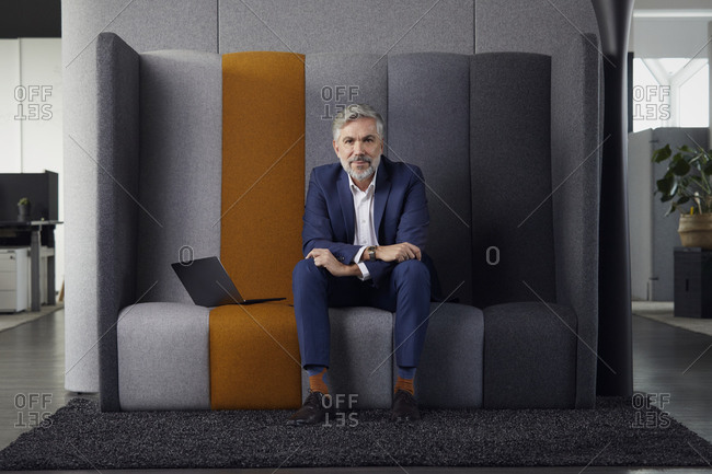 Portrait of mature businessman sitting on couch in office