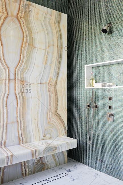 Paradise Valley, Arizona - July 11, 2019: Beautiful stone wall in shower contrasting a mosaic tile wall