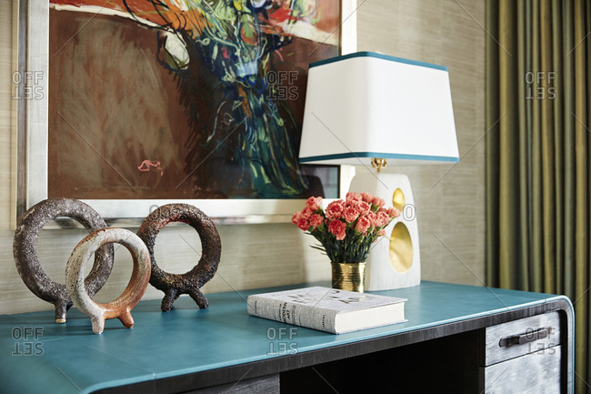 Paradise Valley, Arizona - July 11, 2019: Lamp, flowers and book on a blue desk
