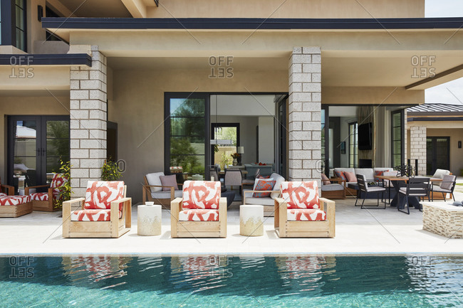 Paradise Valley, Arizona - July 10, 2019: Red pattern lounge chairs beside pool in the backyard of an upscale home