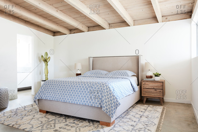Bedroom interior with a gray headboard and blue patterned bed set
