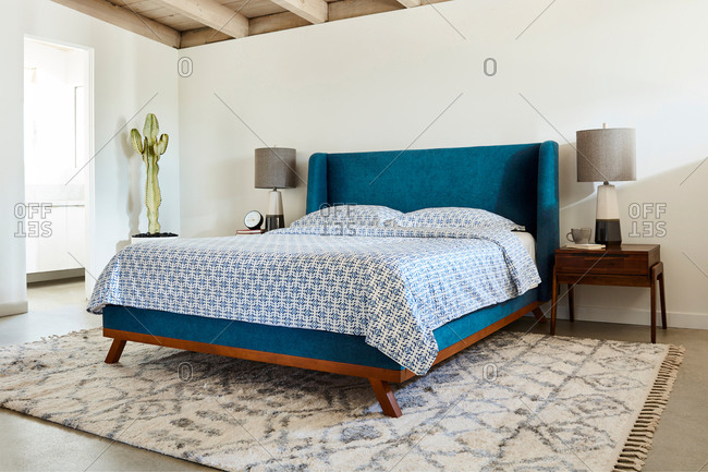 Bedroom interior with a bright blue headboard and blue patterned bed set