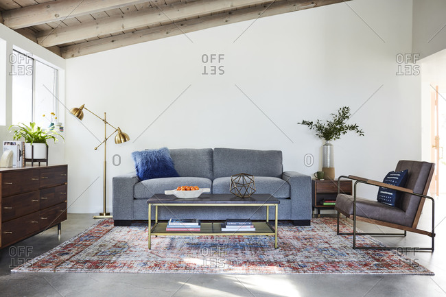 January 31, 2020: Gray sofa and chair in a living room with exposed beam ceiling