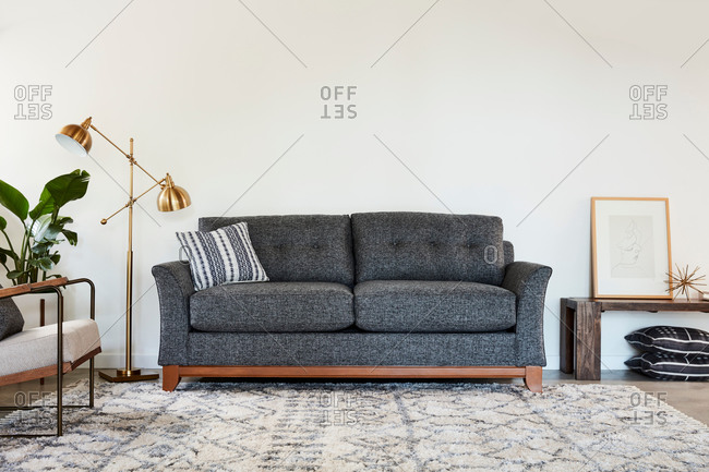 June 1, 2020: Gray and wooden sofa beside a gold lamp
