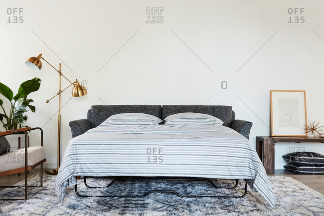 June 1, 2020: Gray sleeper sofa beside a gold lamp