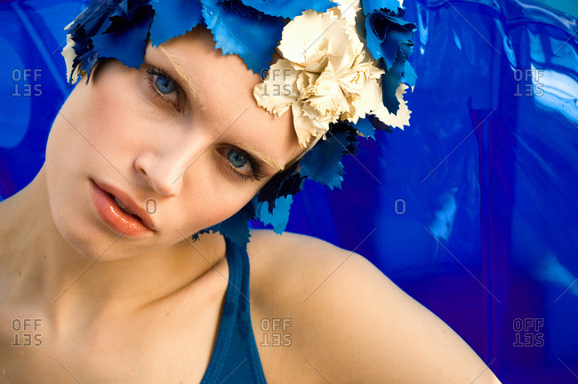 Head and shoulders portrait of blue-eyed woman wearing vintage blue and cream swimming cap.