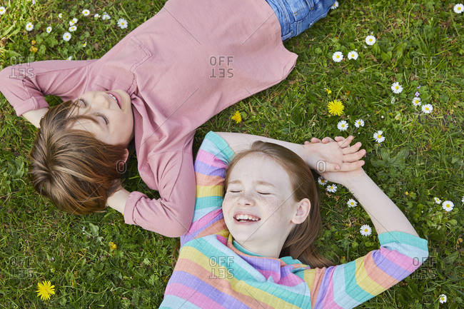 High angle view of boy and girl lying on a spring meadow.