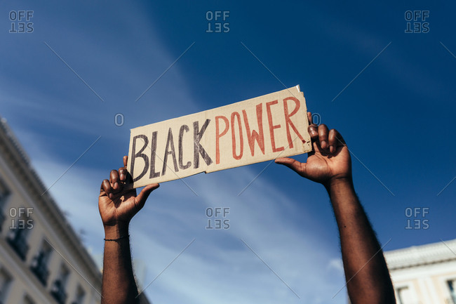 Unrecognizable man protesting at a rally for racial equality holding a "Black Power" poster. Black Lives Matter.