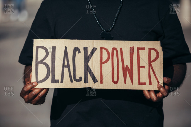 Anonymous man protesting at a rally for racial equality holding a "Black Power" poster. Black Lives Matter.