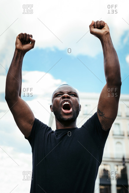 Man protesting at a rally for racial equality raising arms. Black Lives Matter.