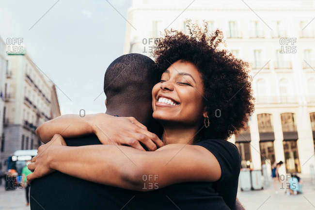 Happy african american couple hugging on the street in a summer day
