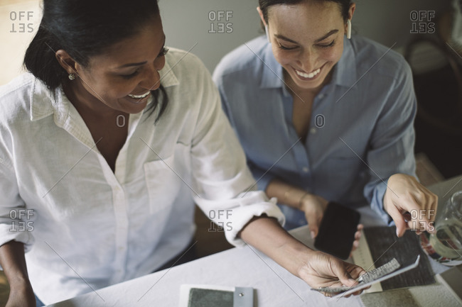 High angle view of smiling architects discussing while working at table in home office