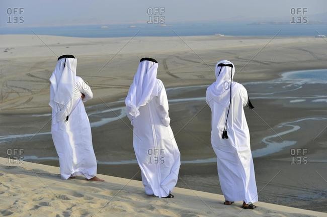 Qatari in traditional clothing with gutra, in front of Khor Al Udeid Beach, Khor El Deid, Inland Sea, desert miracle of Qatar, Emirate of Qatar, Persian Gulf, Middle East, Asia