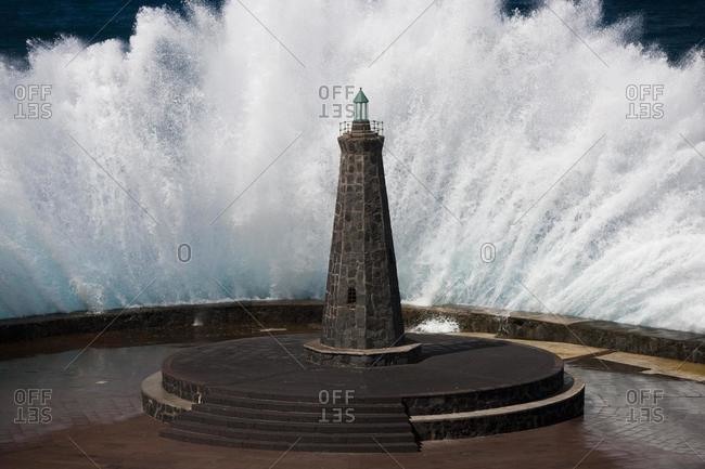 Waves behind a lighthouse on the Atlantic in Bajamar, Tenerife, Spain, Europe