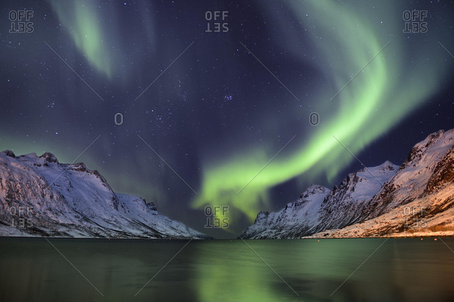 Aurora over a fjord with snow-covered mountains, Ersfjord, Tromso, Troms, Northern Norway, Norway, Europe