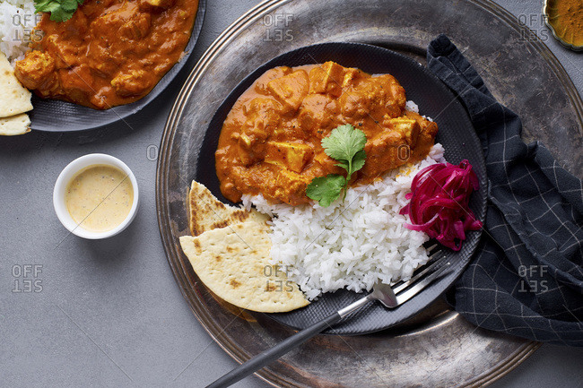 Paneer tikka masala with basmati rice. Indian cuisine, vegetarian dish made of soft cheese cubes cooked in spicy tomato sauce with cream. Top view.