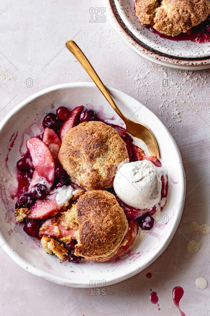 Cranberry apple cobbler with ice cream in a bowl.